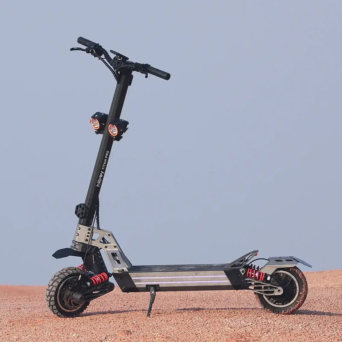 All-terrain electric scooter with dual headlights, rugged tires, and heavy-duty suspension outdoors