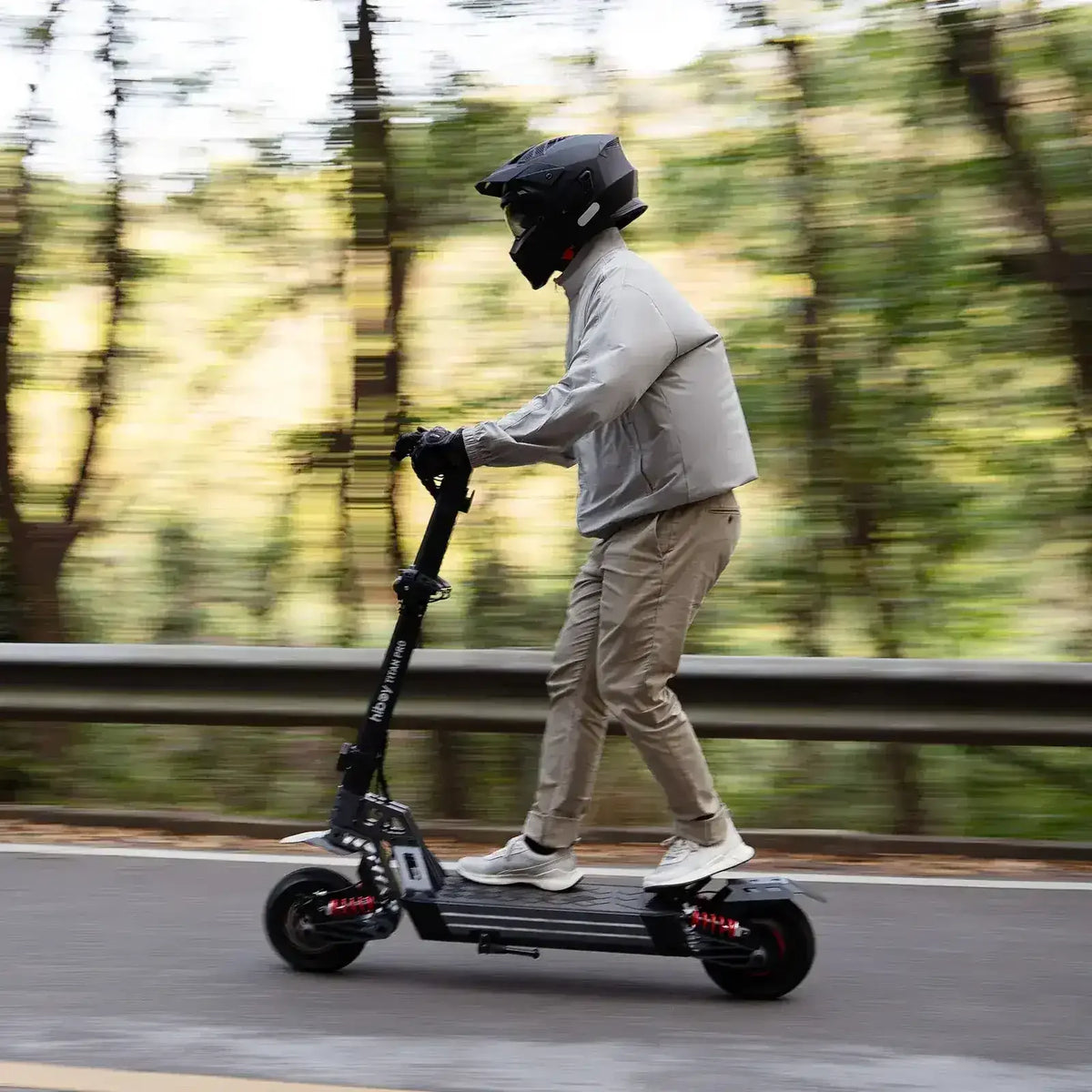 Man riding electric scooter on road with helmet, forest background, outdoor transportation