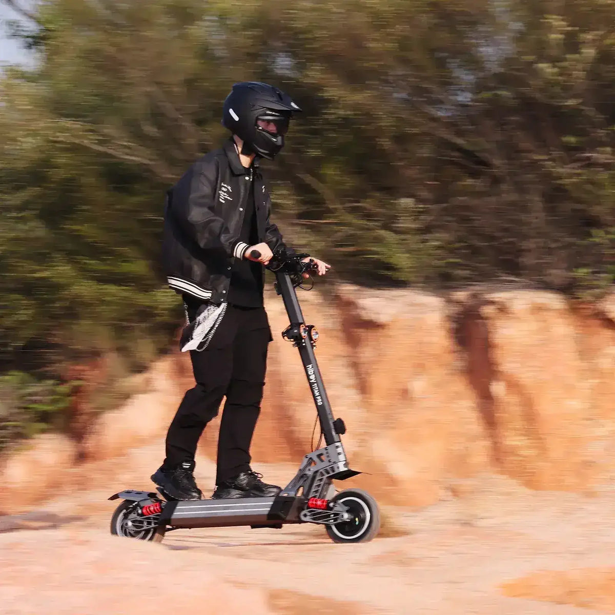 Rider with helmet on electric scooter outdoors on rocky terrain