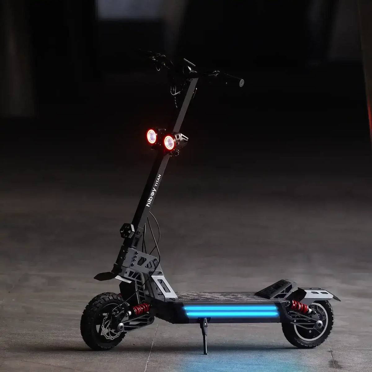 Off-road electric scooter with dual headlights, rugged tires, and side LED lights on pavement