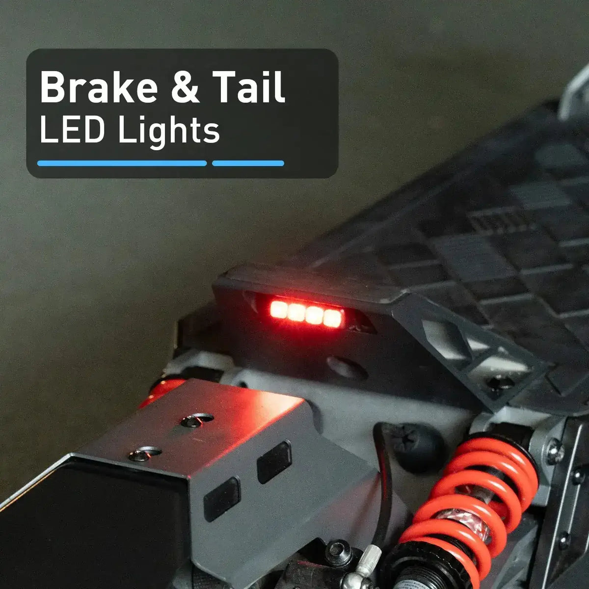 ATV rear with illuminated LED brake and tail lights, visible red coil spring suspension