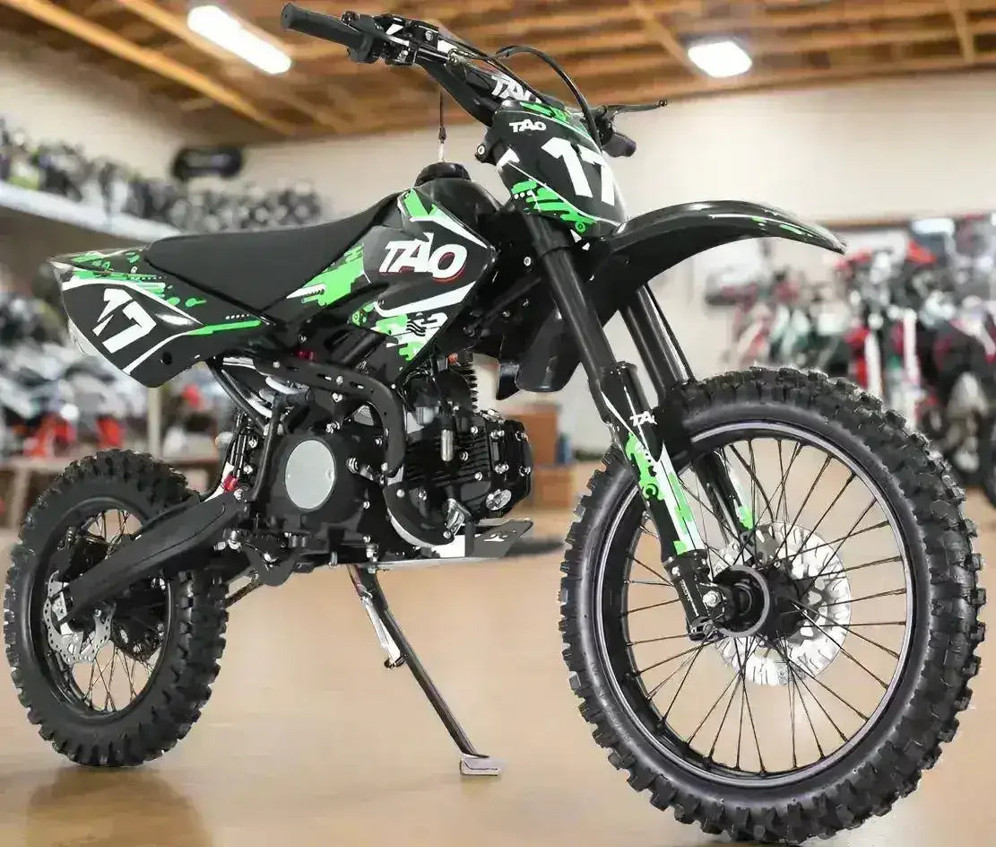 Green and black Tao Motor DB17 125cc youth dirt bike with number 17 plates, angled front view in showroom