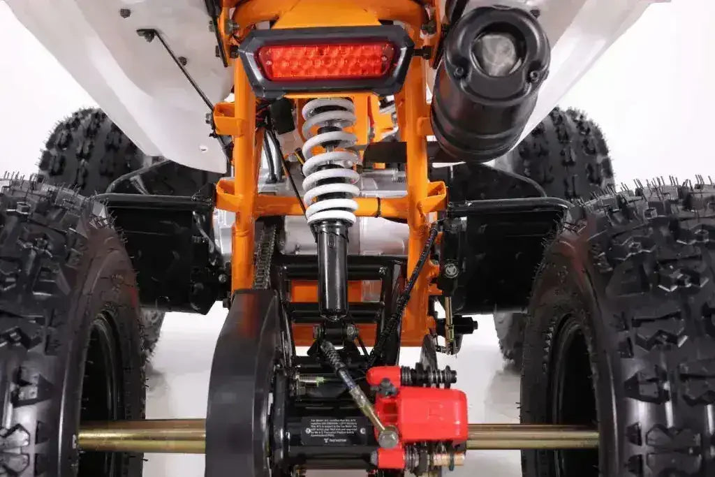 Rear view of ATV suspension, exhaust, and rugged off-road tires on white background