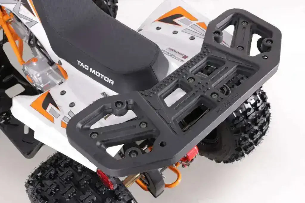 Close-up of ATV rear rack, seat, and rugged tires on a white and orange quad bike