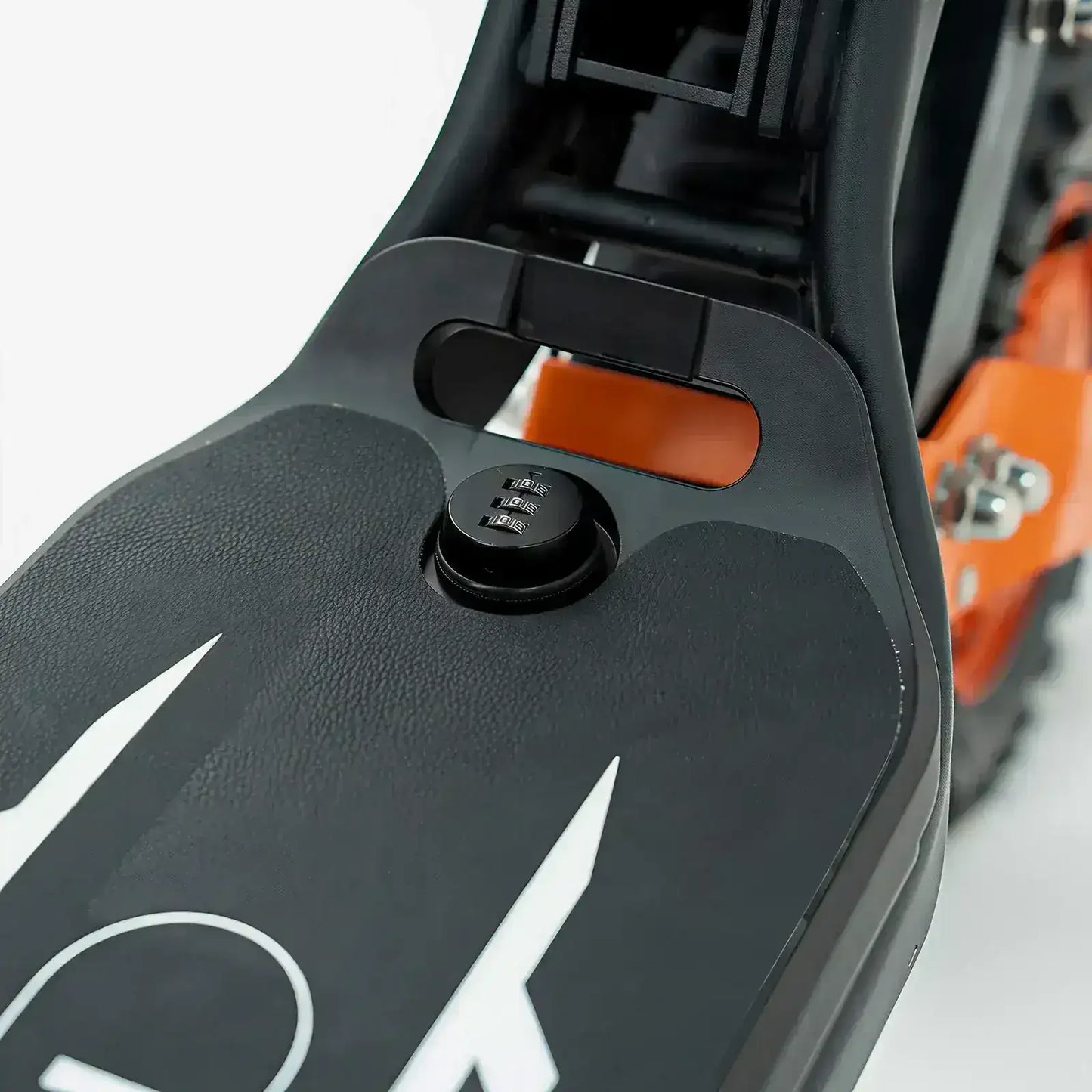 Close-up of ATV or dirt bike seat with black plastic cover and visible lock mechanism