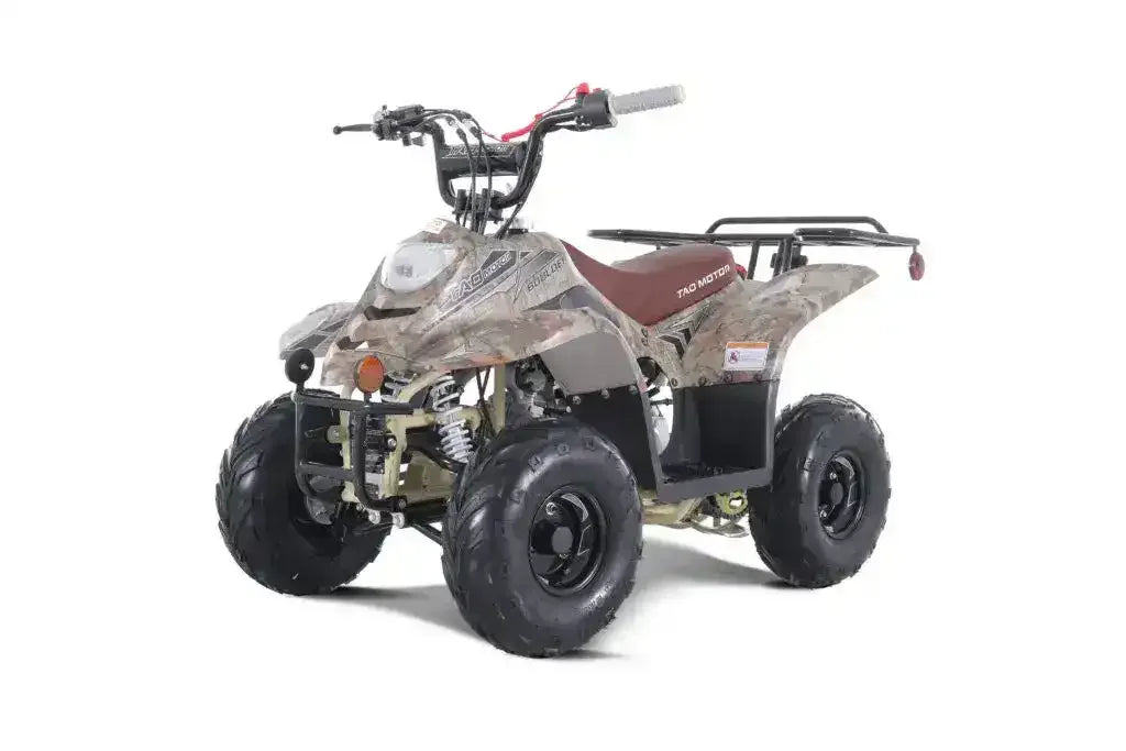 Camo kids ATV four-wheeler with rugged tires and rear cargo rack on white background