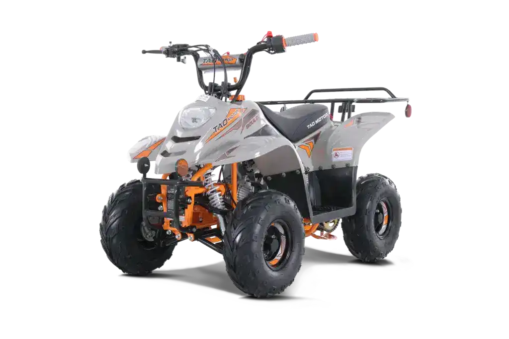 Gray and orange youth ATV with rugged tires and front suspension, angled driver side view