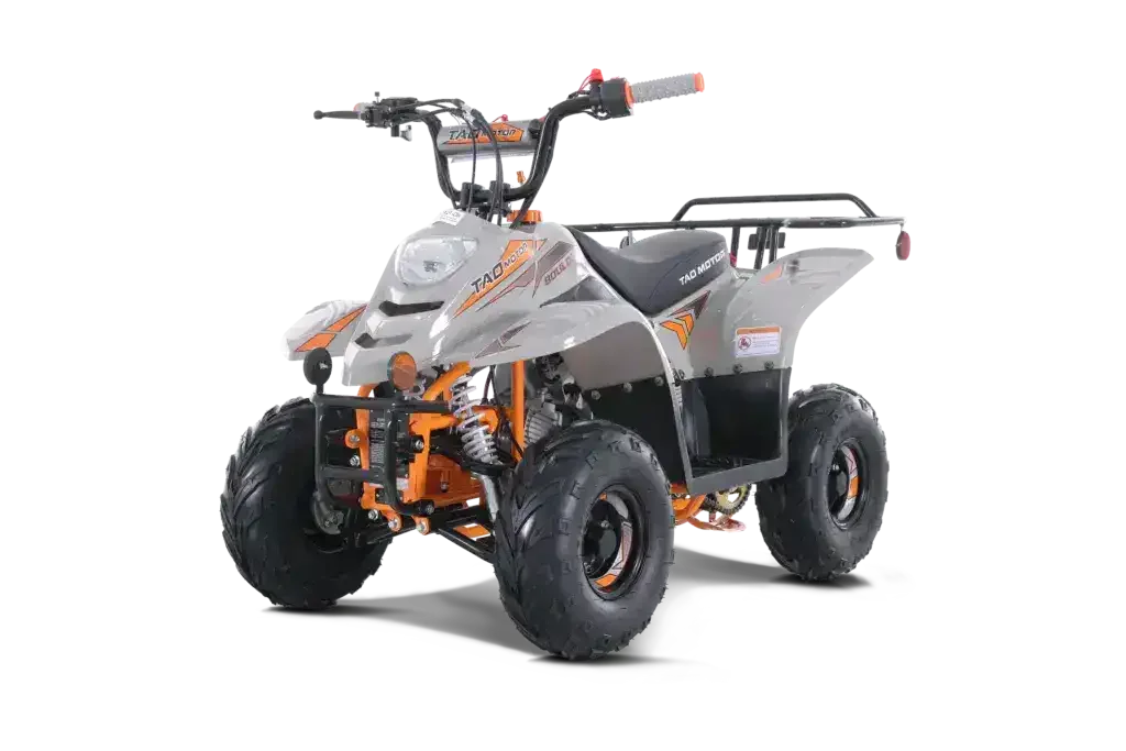 Gray and orange youth ATV with rugged tires and front suspension, angled driver side view