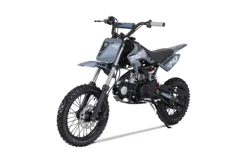 Gray youth off-road dirt bike with knobby tires, angled three-quarters view on white background
