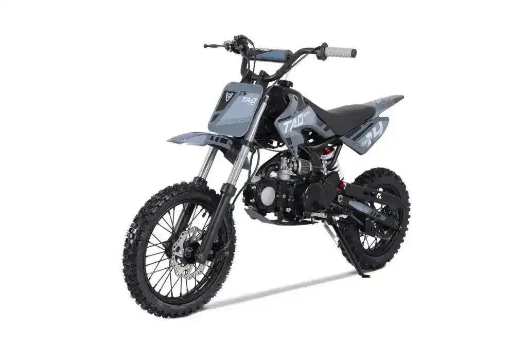 Gray youth off-road dirt bike with knobby tires, angled three-quarters view on white background