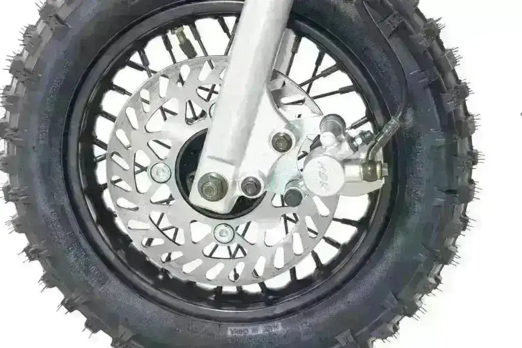 Close-up of dirt bike front tire with knobby tread and disc brake.