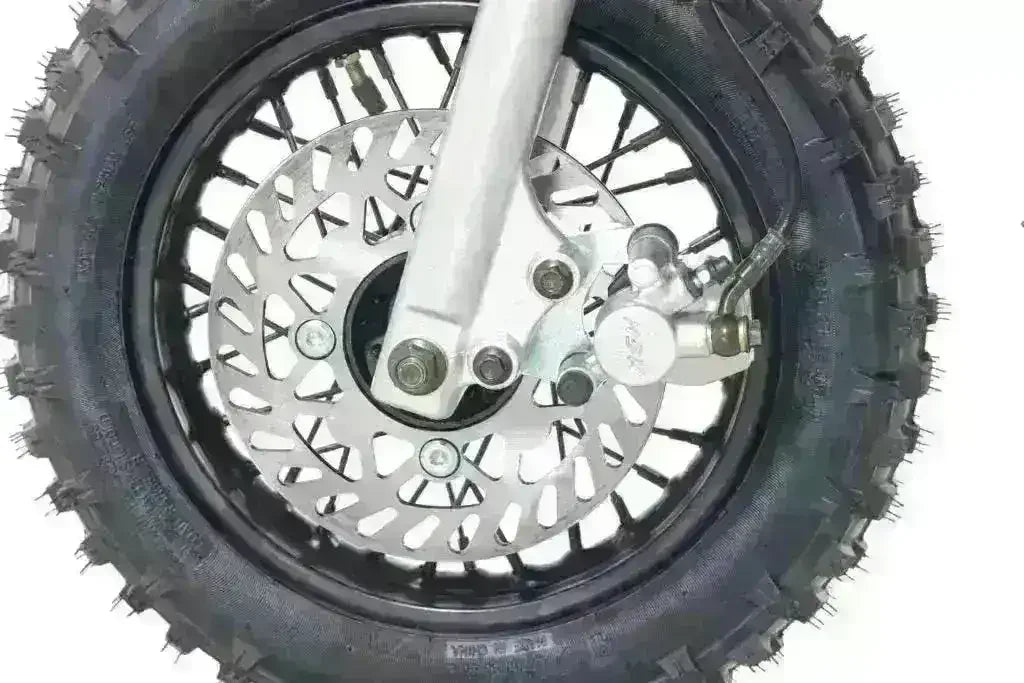 Close-up of dirt bike front tire with knobby tread and disc brake.