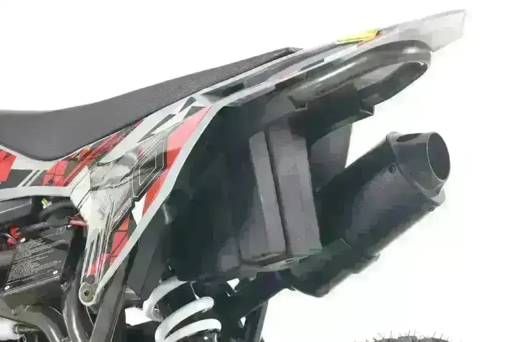 Closeup of ATV rear exhaust system and suspension with red and black graphics.