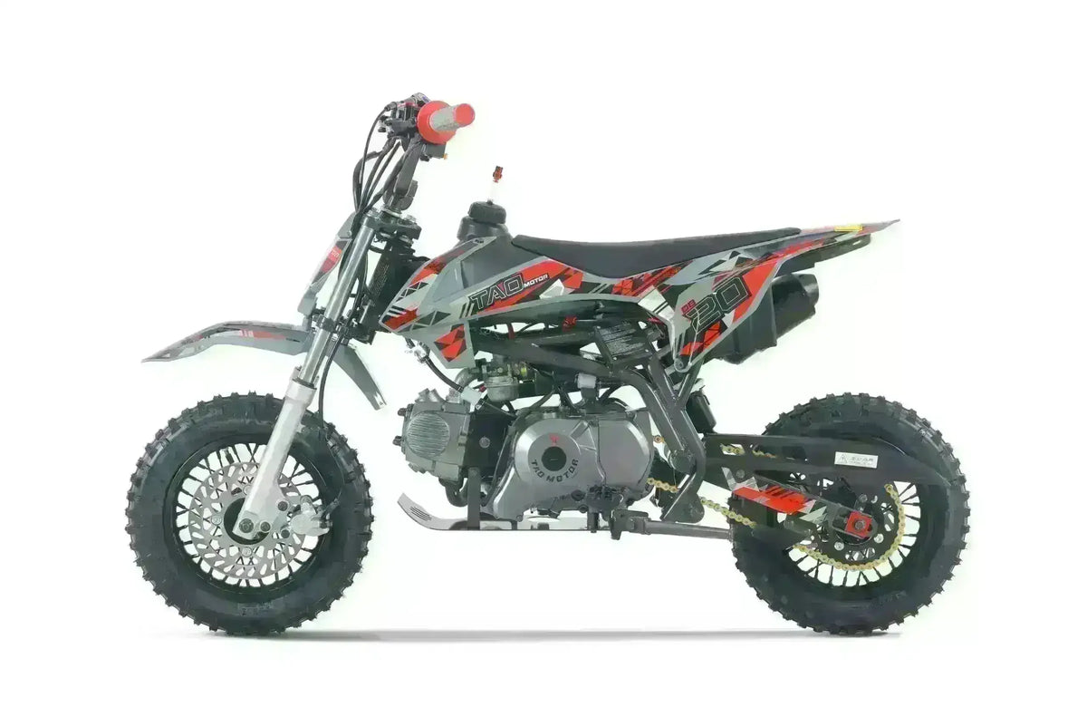 Gray and red dirt bike with knobby tires and graphic decals, side view on white background