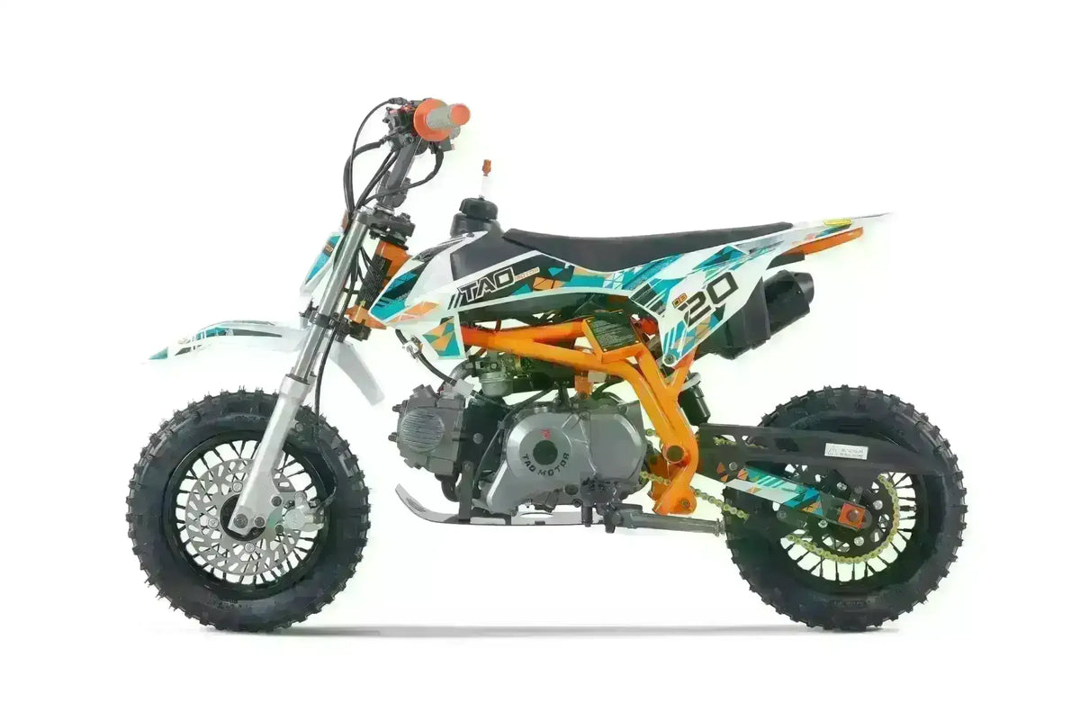 Orange and white kids dirt bike with knobby tires and graphic decals, side view
