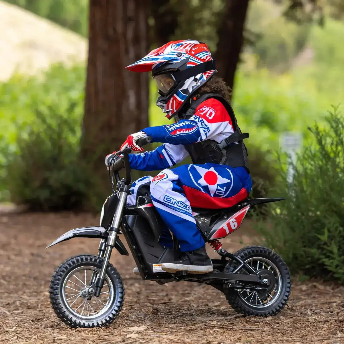 Kid riding a small dirt bike outdoors with motocross gear and helmet, beginner off-road motorcycle