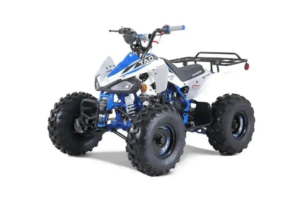 Blue and white youth ATV with large off-road tires and rear cargo rack on white background