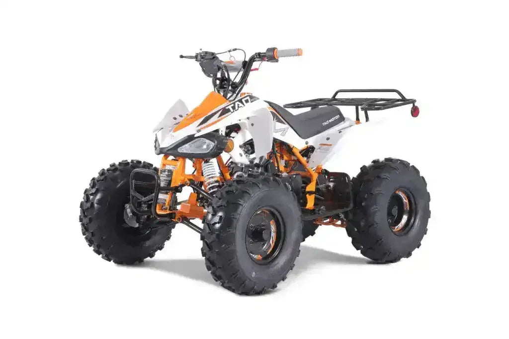Youth ATV with white and orange body, rugged tires, and front brush guard on white background.