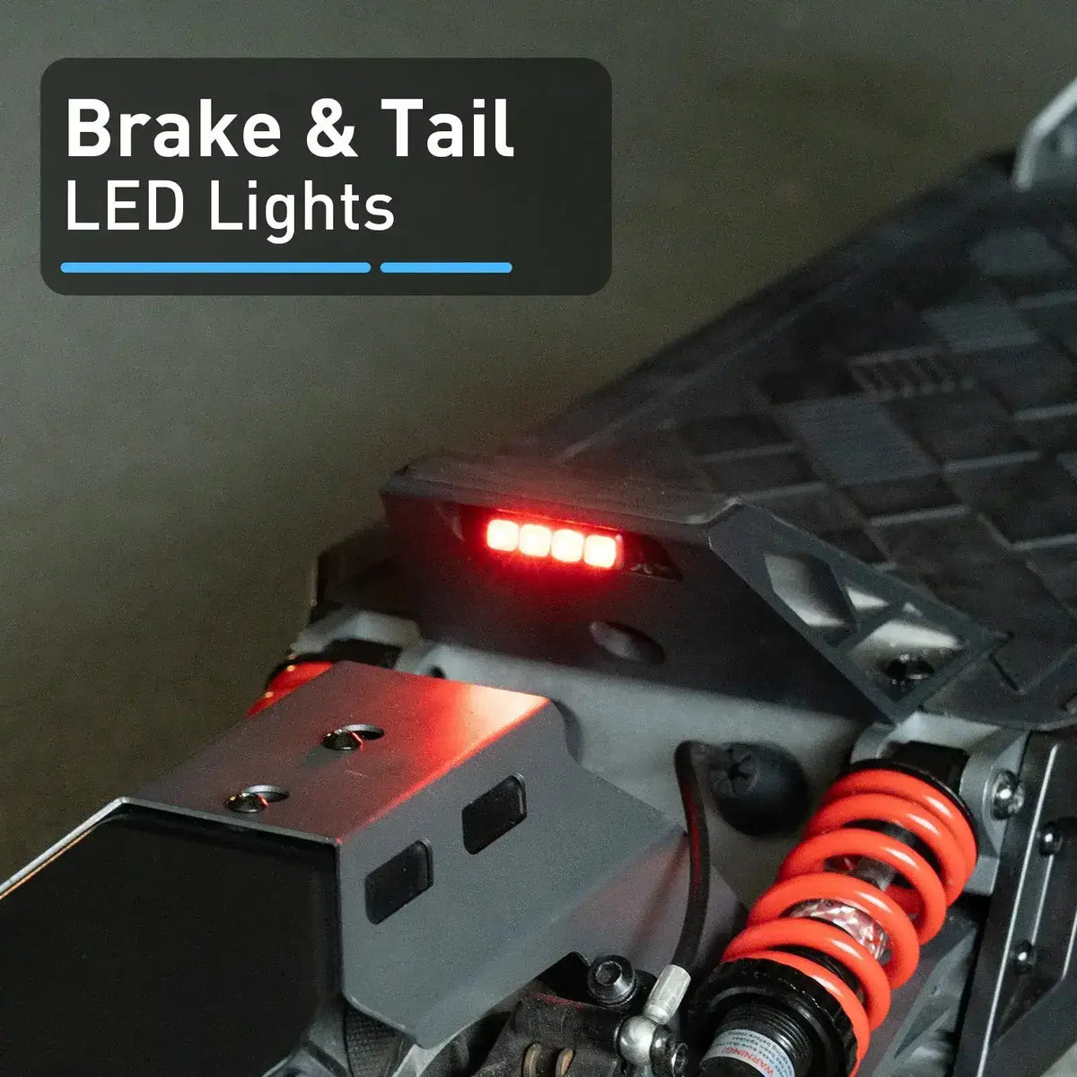 Close-up of ATV rear brake and tail LED lights with red suspension coil