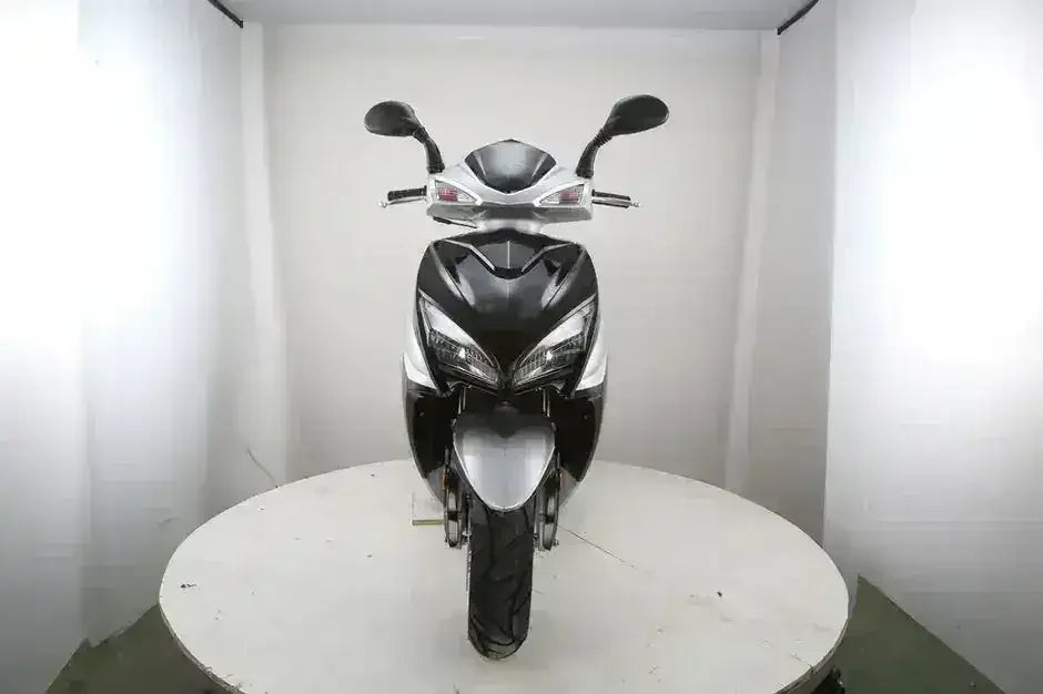 Front view of a black and silver RPS Adventure scooter showing headlight assembly and mirrors on a display platform