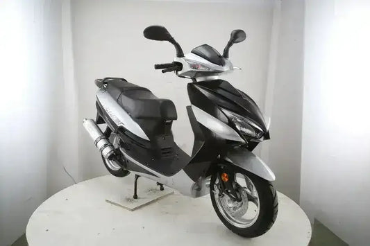 Black and silver motor scooter with dual mirrors and sporty design in a studio setting