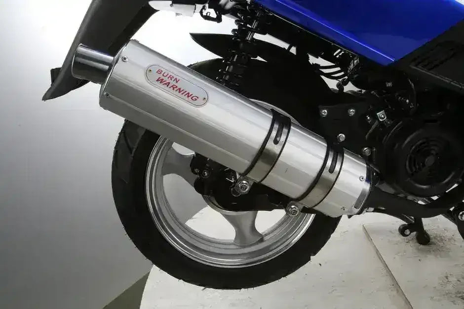 Close-up of the RPS Adventure scooter chrome exhaust with burn-warning label, rear wheel and suspension spring