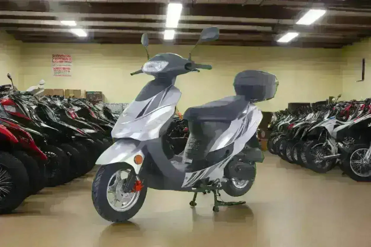 Classic 50cc scooter with storage box in a showroom lined with motorcycles and scooters