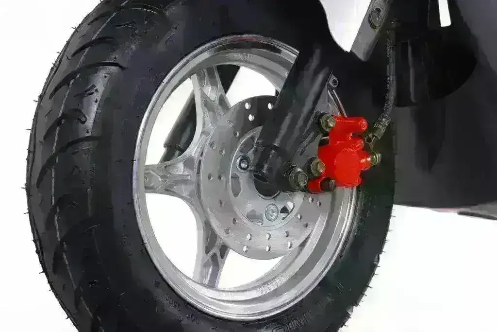 Close-up of a scooter front wheel with disc brake and black tire on white background