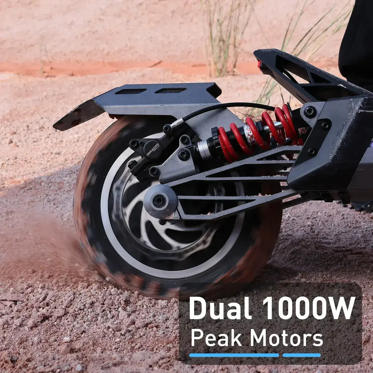 Close-up of off-road scooter rear wheel with dual 1000W motors and red suspension on dirt terrain