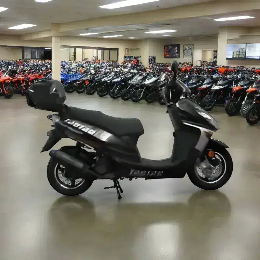 Black motor scooter with rear storage box in showroom lined with ATVs and scooters