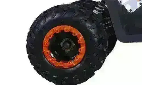 Close-up of utility ATV rear tire with orange rim and rugged tread for all-terrain use