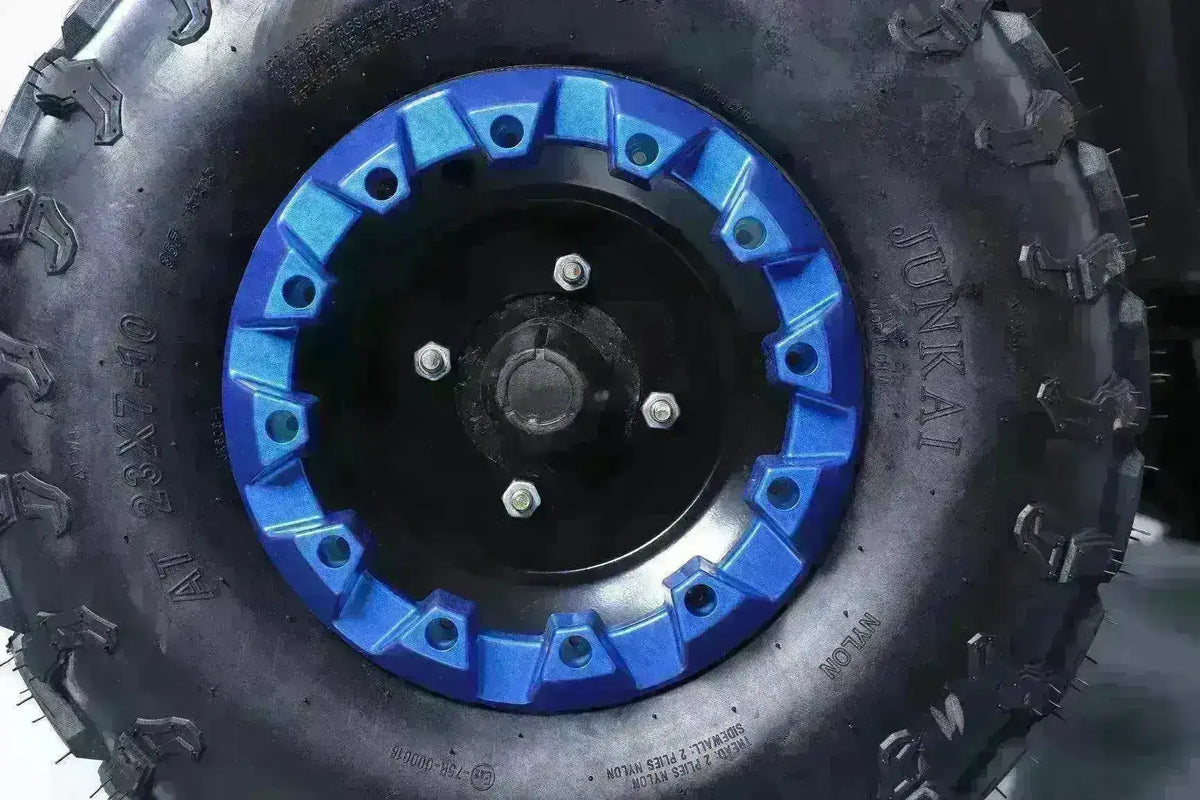 Close-up of all-terrain ATV tire with blue rim and rugged tread pattern