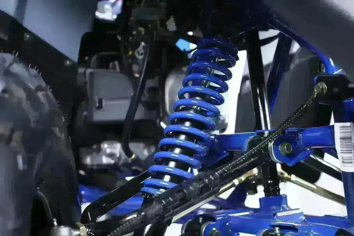 Close-up of blue coil spring suspension on a 200cc utility ATV