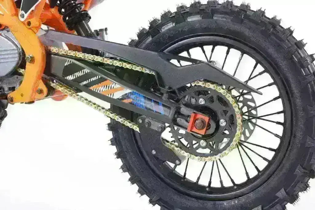 Close-up of DB27 125cc youth dirt bike rear tire and chain on white background