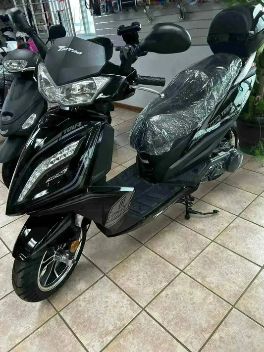 Black 150cc gas powered scooter with covered seat on showroom floor