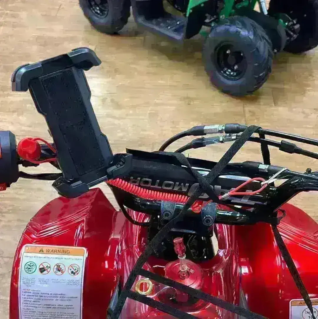 Handlebar cell phone holder mounted on red ATV with visible cables and warning label