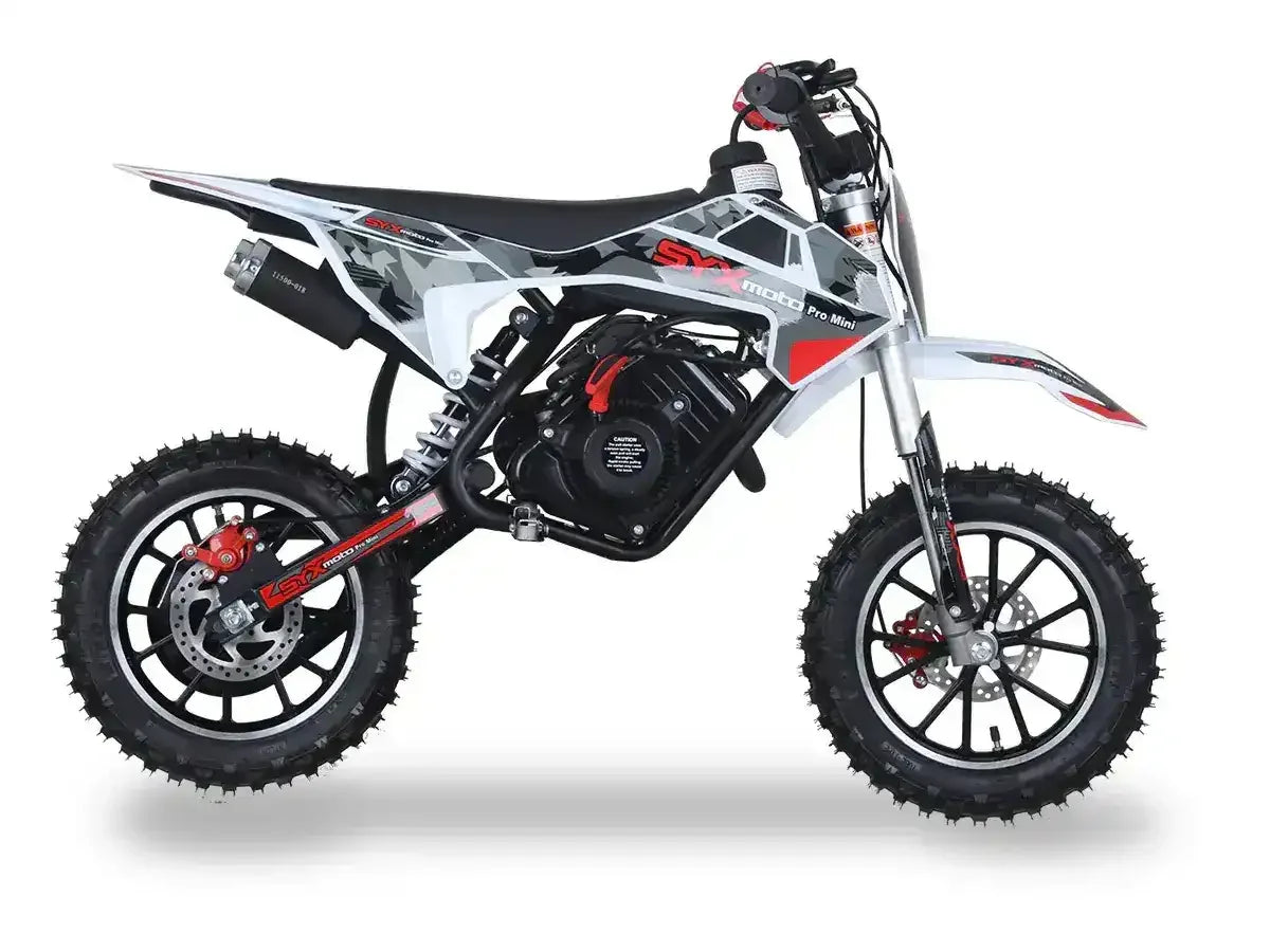 Mini dirt bike with knobby tires, black and white frame, red accents, side view