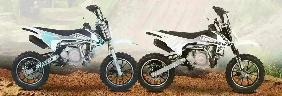 Two SYXmoto 60cc kids pit bikes with off-road tires parked on dirt
