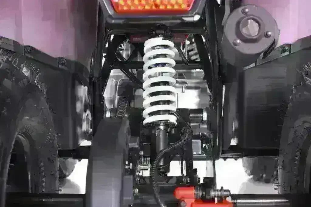 Close-up of rear suspension and tires on youth 125cc utility ATV