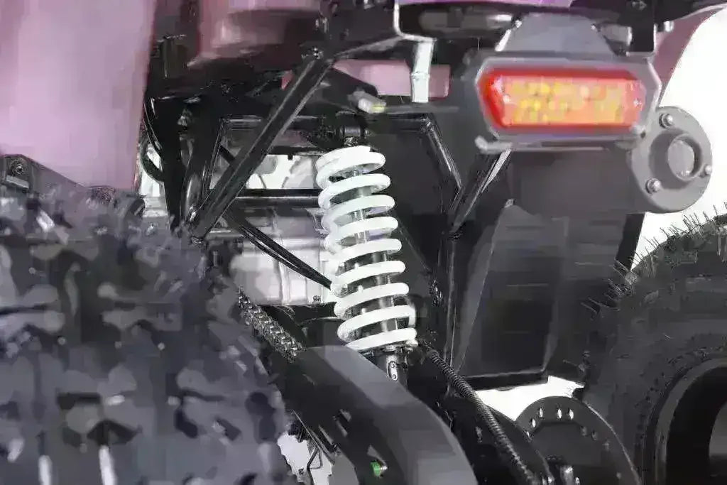 Rear suspension detail and off-road tires of a youth utility ATV