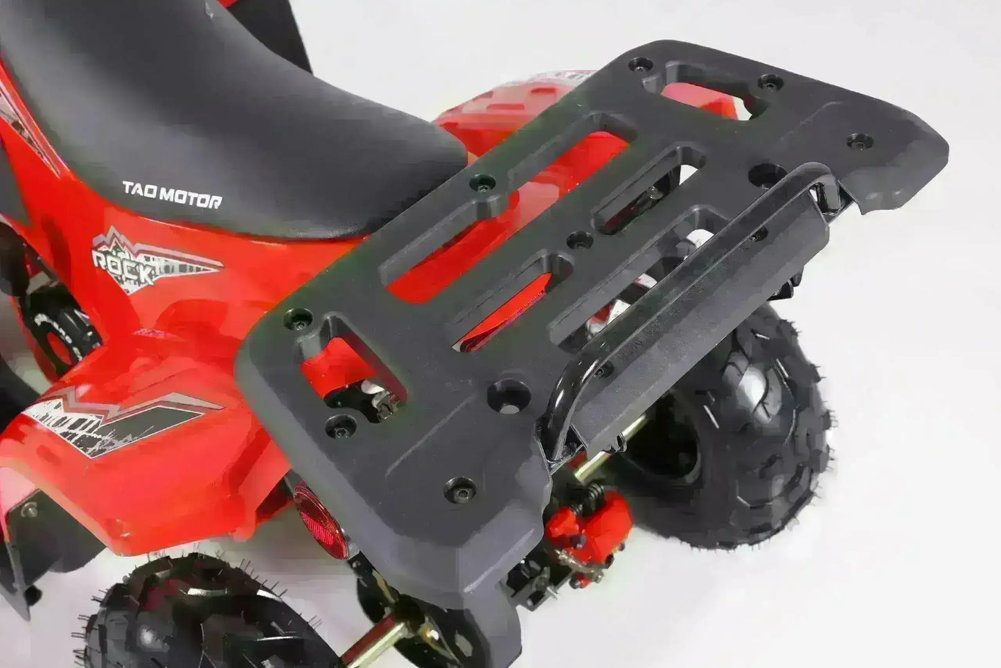 Close-up of rear cargo rack and seat on red kids ATV with rugged tires