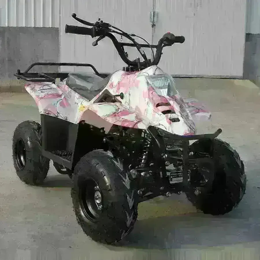 Small pink camouflage kids ATV four-wheeler with rugged tires on pavement