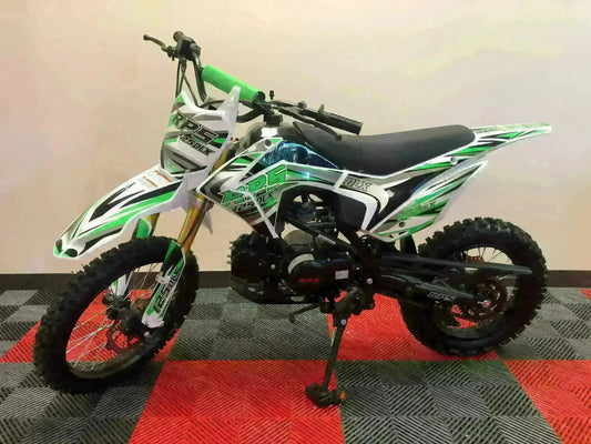Green and white RPS 125 DLX dirt bike with knobby tires on showroom floor