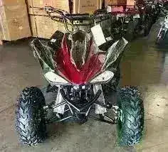 Red and black 200cc automatic sports quad ATV with off-road tires in a warehouse