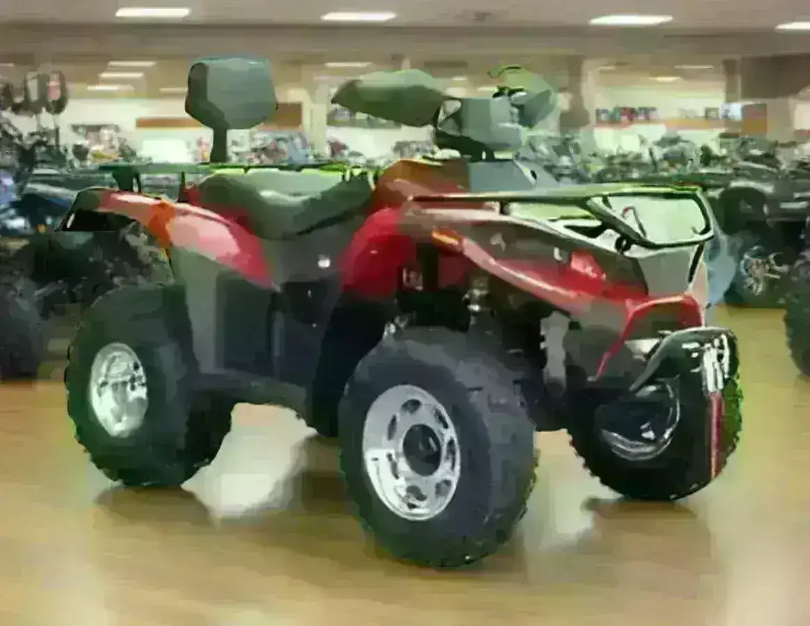 Red 4x4 utility ATV with rear rack and large tires displayed indoors