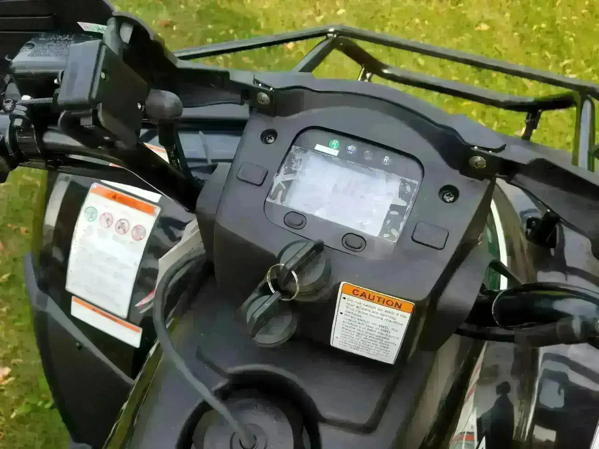 Digital control panel and handlebars of a 300cc 4x4 utility ATV on grass