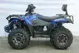 Blue 4x4 utility ATV with large tires, rear rack, and backrest on display indoors