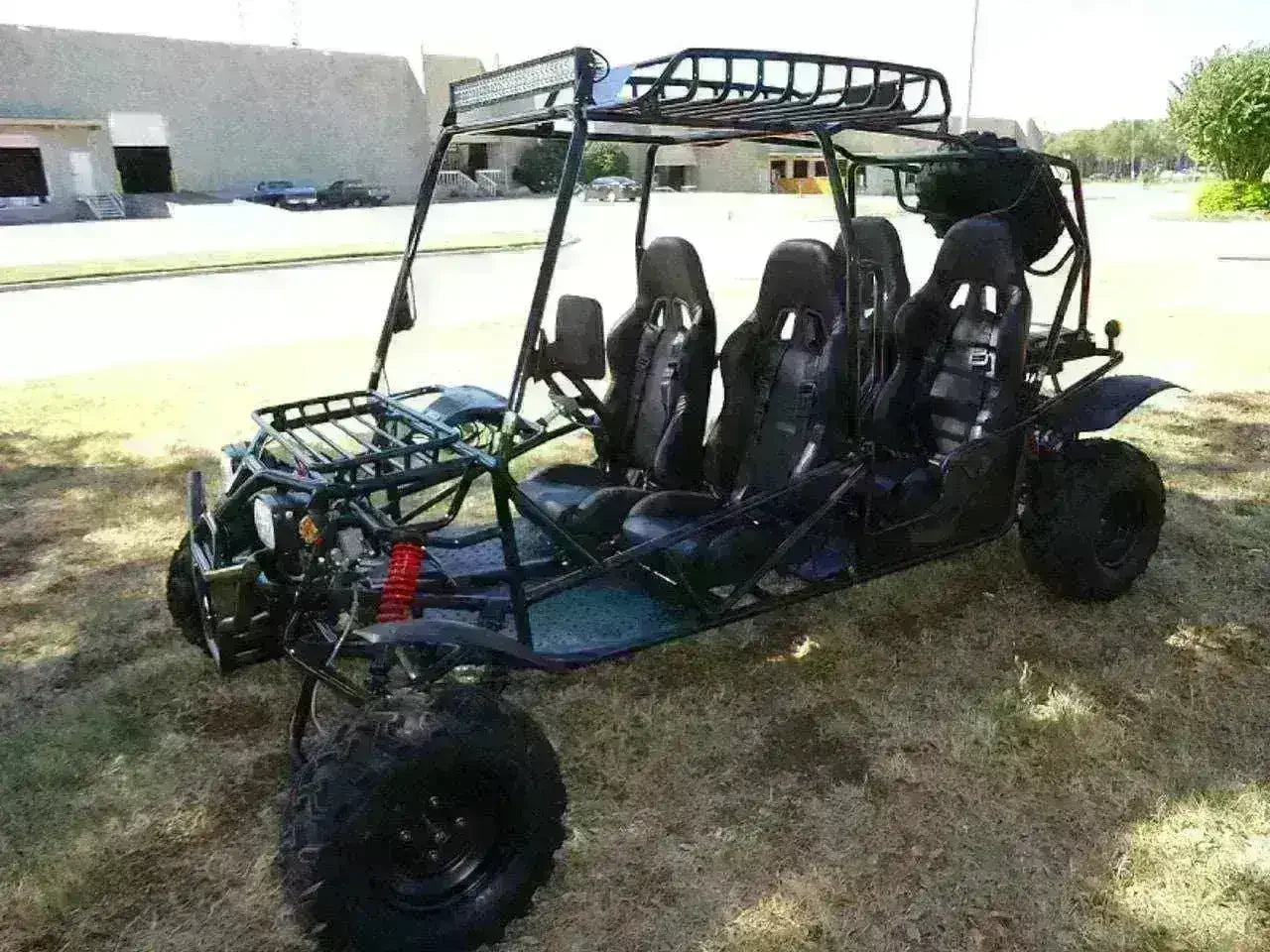 Four-seat 200cc go-kart with roll cage and off-road tires parked on grass