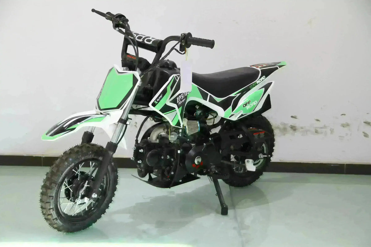 Green and black 70cc kids dirt bike with training wheels, off-road style, on showroom floor