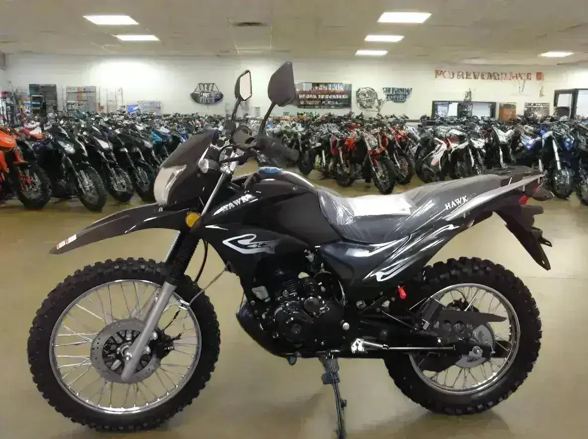Black Hawk dirt bike with knobby tires displayed in a motorcycle showroom
